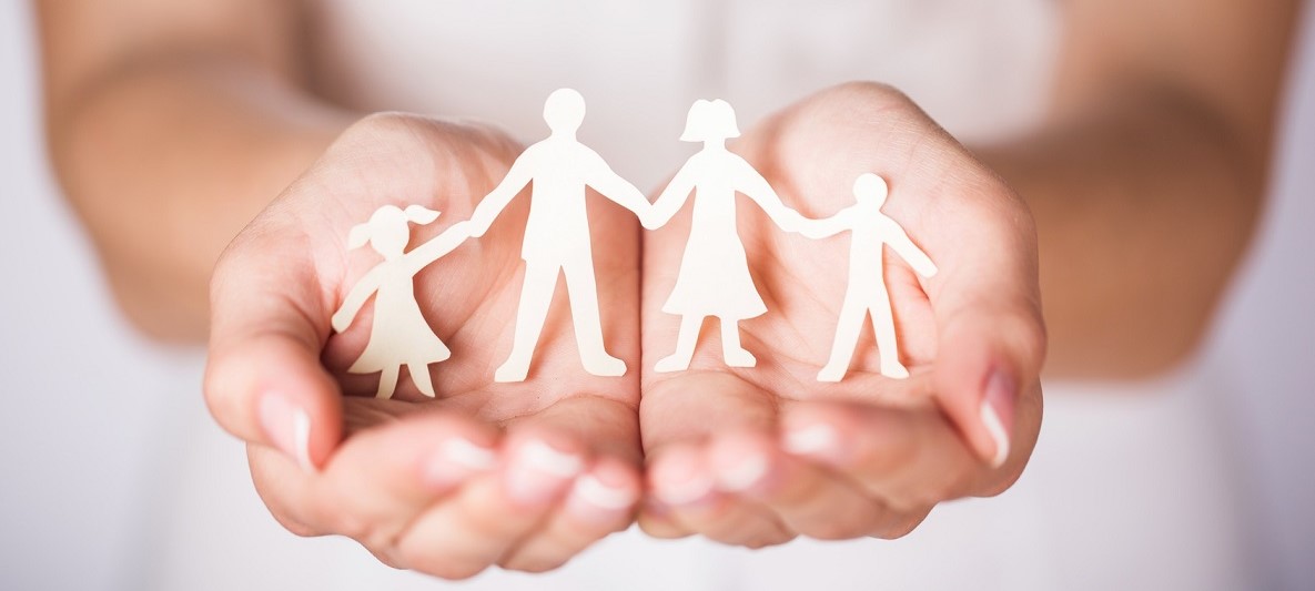 Hände halten Familie aus Papier Weibliche Hände halten Papierfiguren einer Familie mit einem Jungen und einem Mädchen
